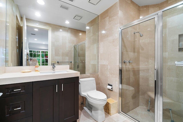 bathroom with vanity, tile walls, walk in shower, and toilet