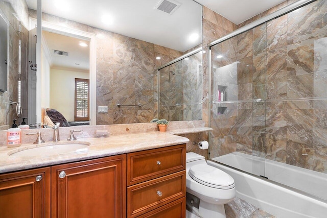 full bathroom with vanity, toilet, and combined bath / shower with glass door