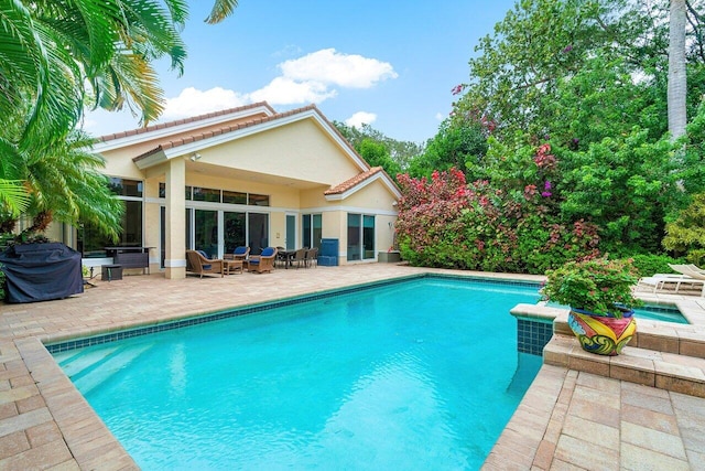 view of pool featuring a grill, a jacuzzi, and a patio