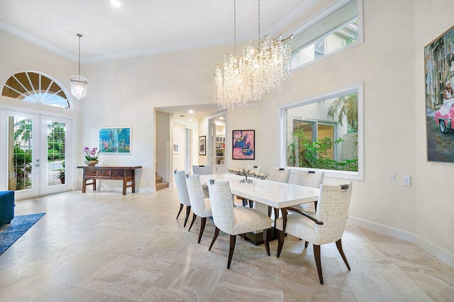 dining room featuring french doors, a towering ceiling, crown molding, and a chandelier