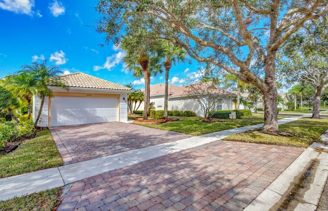 view of front of property with a tiled roof, decorative driveway, and a front yard