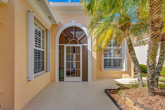 view of exterior entry with a patio