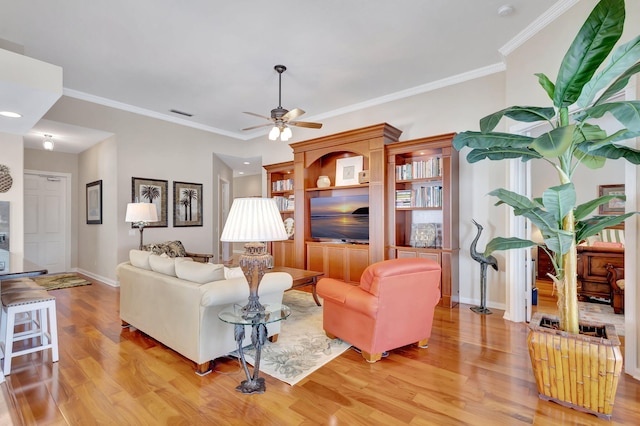 living room featuring crown molding, ceiling fan, and light hardwood / wood-style floors