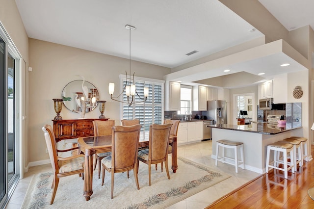 tiled dining area with a notable chandelier and sink