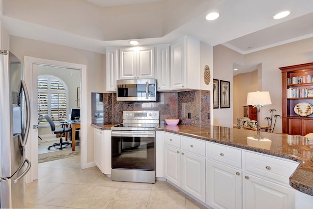 kitchen featuring crown molding, appliances with stainless steel finishes, tasteful backsplash, white cabinets, and dark stone counters