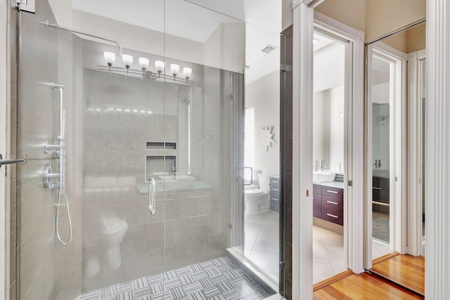 bathroom featuring hardwood / wood-style flooring, an enclosed shower, vanity, a notable chandelier, and toilet