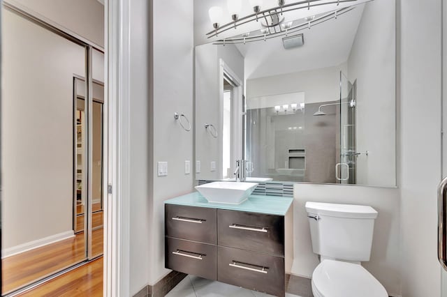 bathroom with hardwood / wood-style flooring, vanity, an enclosed shower, and toilet