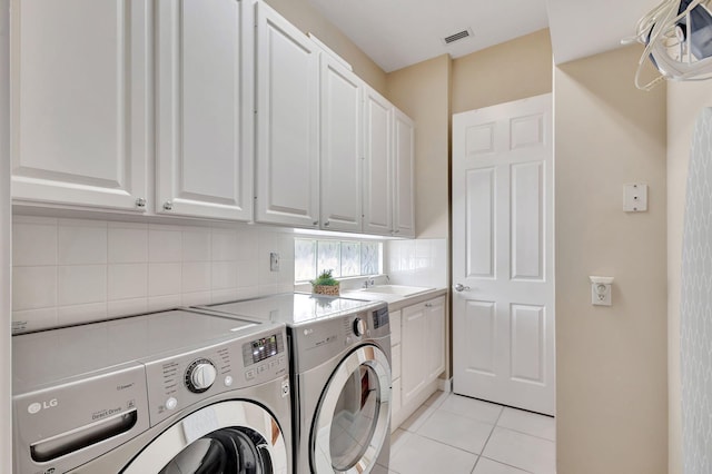 clothes washing area featuring cabinets, sink, independent washer and dryer, and light tile patterned flooring