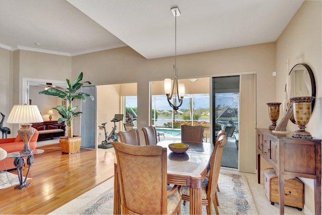 dining area featuring a notable chandelier, ornamental molding, and light wood-type flooring