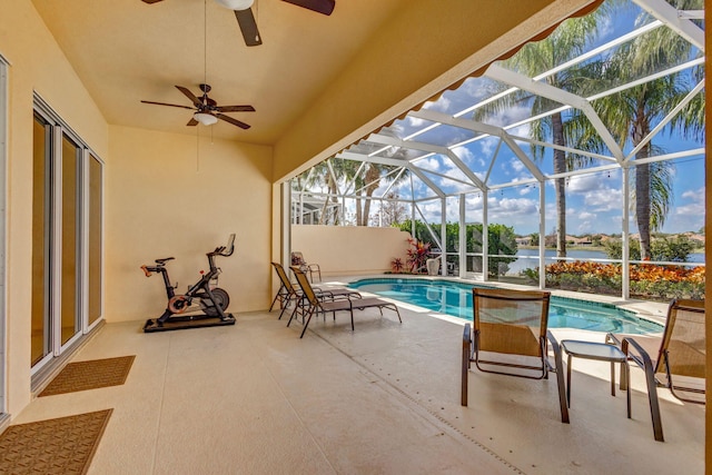 pool with ceiling fan, a patio, a water view, and a lanai