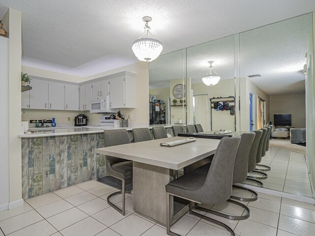 tiled dining area featuring a textured ceiling