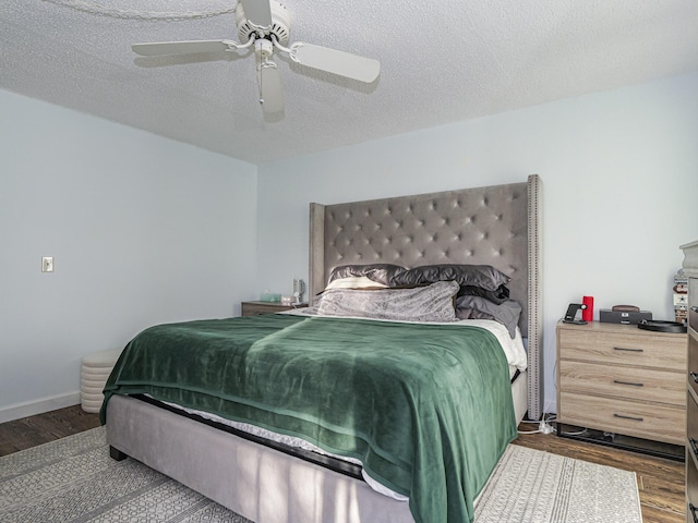 bedroom featuring dark hardwood / wood-style flooring, a textured ceiling, and ceiling fan