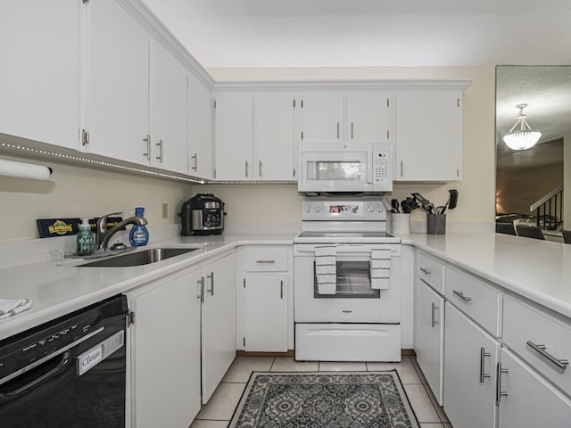 kitchen featuring sink, white appliances, light tile patterned floors, and white cabinets