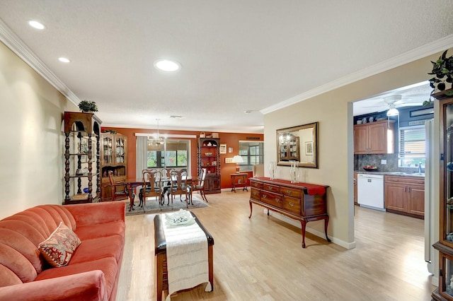 living room with ornamental molding, sink, a wealth of natural light, and light hardwood / wood-style floors