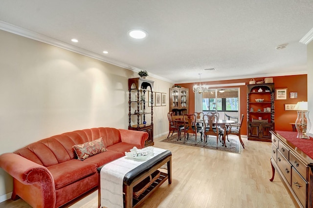 living room with crown molding, an inviting chandelier, and light hardwood / wood-style flooring