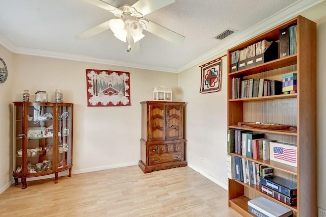 misc room with ceiling fan, ornamental molding, light hardwood / wood-style floors, and a textured ceiling