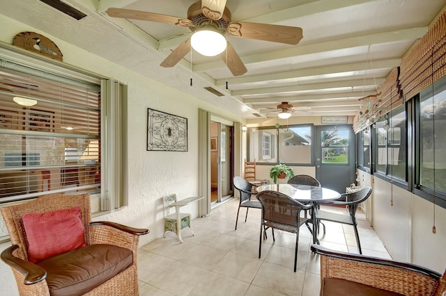 sunroom / solarium featuring beamed ceiling and ceiling fan