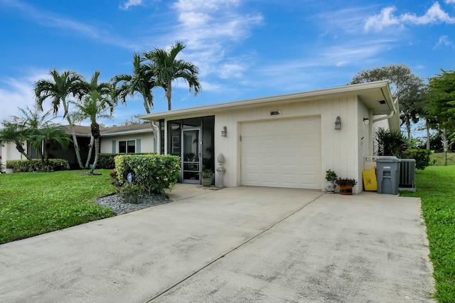 single story home with driveway, a front lawn, and a garage