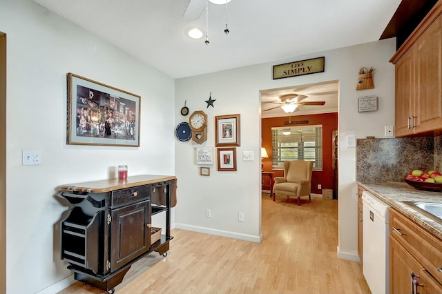 kitchen with baseboards, ceiling fan, dishwasher, light wood-type flooring, and backsplash