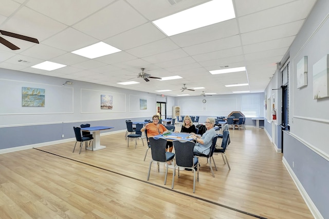 dining space featuring light wood-type flooring, baseboards, and a ceiling fan