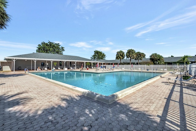 community pool featuring fence and a patio area