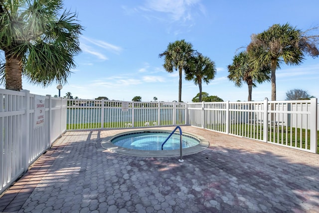 view of swimming pool featuring a community hot tub and a fenced backyard