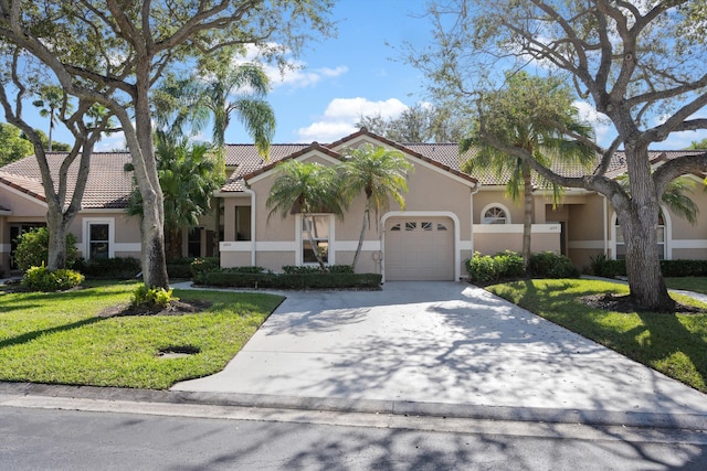 mediterranean / spanish-style house featuring a garage and a front yard