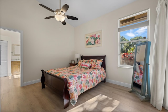 bedroom with ensuite bathroom, lofted ceiling, light wood-type flooring, and ceiling fan