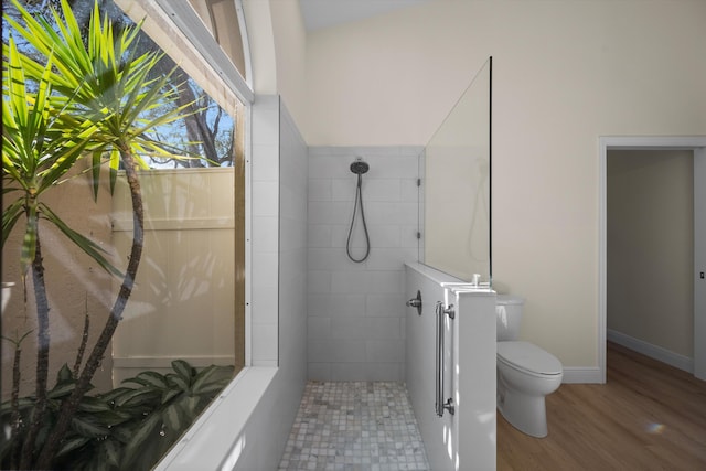 bathroom with walk in shower, toilet, and hardwood / wood-style floors