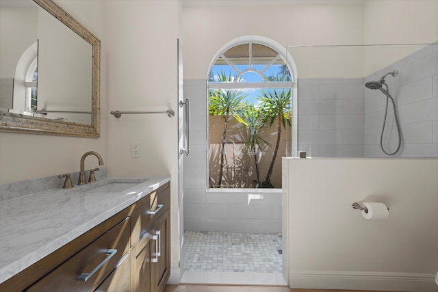 bathroom with vanity and tiled shower