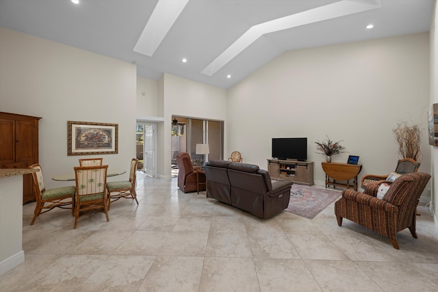 living room featuring high vaulted ceiling and a skylight