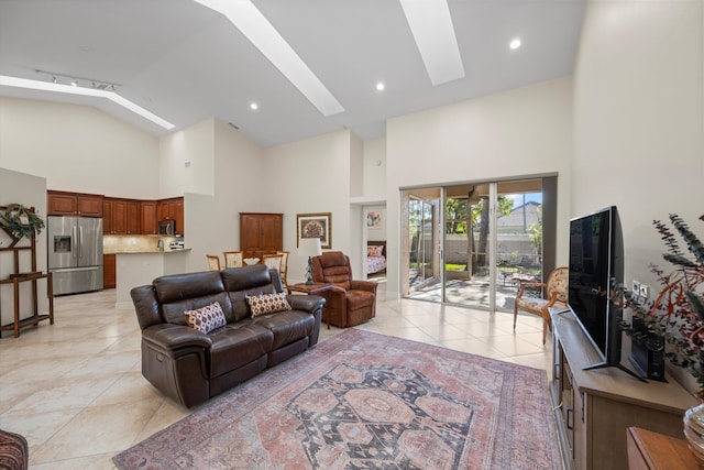 tiled living room with a skylight and high vaulted ceiling