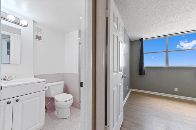 spare room featuring a textured ceiling and light hardwood / wood-style floors