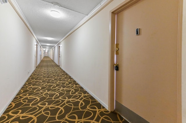 hall featuring ornamental molding, carpet floors, and a textured ceiling