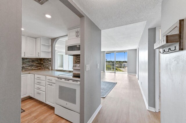 kitchen featuring tasteful backsplash, sink, white cabinets, white appliances, and light hardwood / wood-style flooring