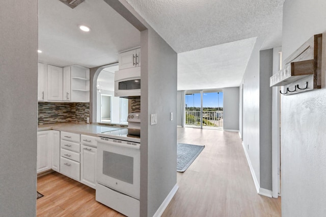 kitchen featuring white cabinetry, white appliances, light hardwood / wood-style floors, and decorative backsplash