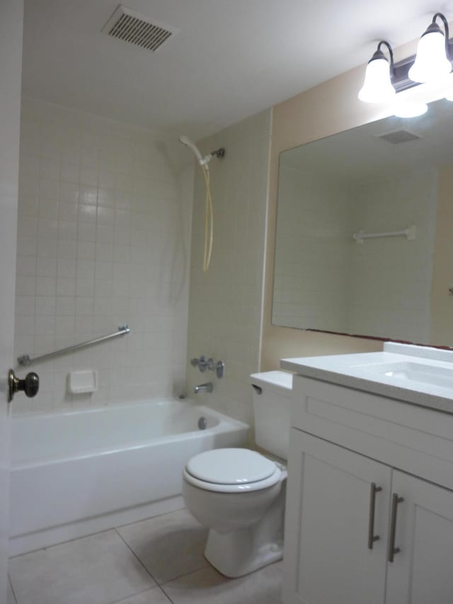 full bathroom featuring tiled shower / bath, vanity, tile patterned floors, and toilet