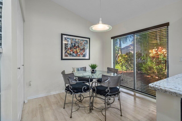 dining space with lofted ceiling and light hardwood / wood-style floors