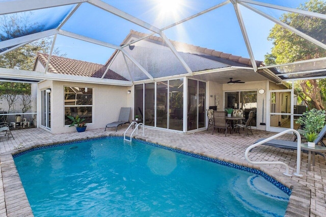 view of pool featuring a patio, a sunroom, ceiling fan, and glass enclosure