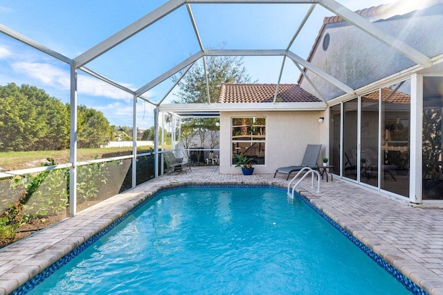 view of swimming pool featuring a lanai and a patio area