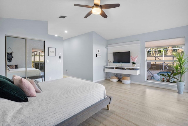 bedroom with ceiling fan, lofted ceiling, a closet, and light wood-type flooring