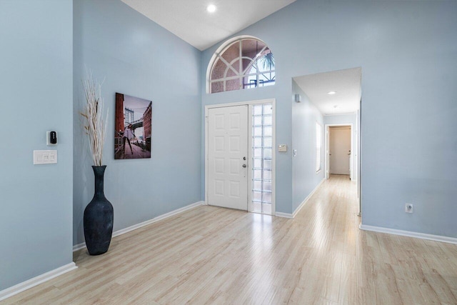 entrance foyer featuring high vaulted ceiling and light hardwood / wood-style floors