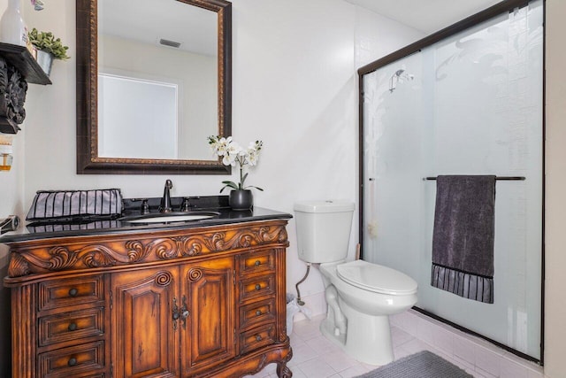 bathroom featuring vanity, tile patterned floors, toilet, and walk in shower