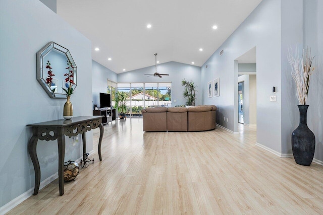 living room featuring high vaulted ceiling, ceiling fan, and light wood-type flooring