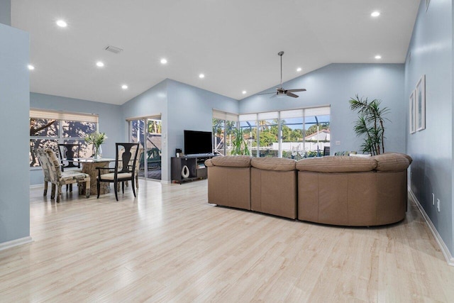 living room with ceiling fan, high vaulted ceiling, and light wood-type flooring