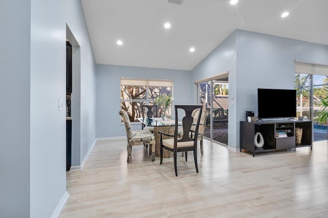 dining room featuring lofted ceiling and light hardwood / wood-style flooring