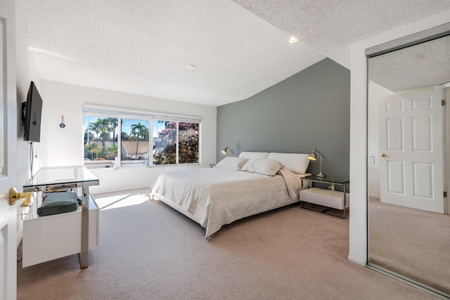 carpeted bedroom featuring lofted ceiling and a textured ceiling