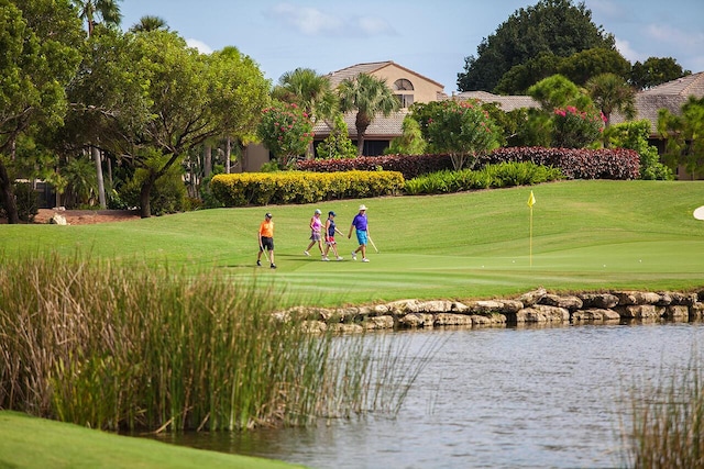 view of property's community with a water view and a yard