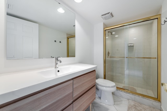 bathroom featuring toilet, vanity, and a shower with shower door