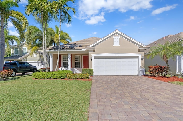 single story home featuring a garage and a front lawn